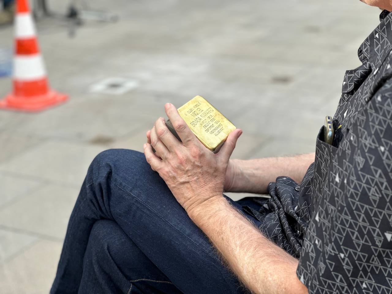 El representant d'un dels olesans homenatjats sosté la seva llamborda Stolpersteine