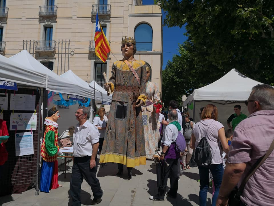 Plaça de l'ajuntament amb estands de les entitats i els gegants passejant