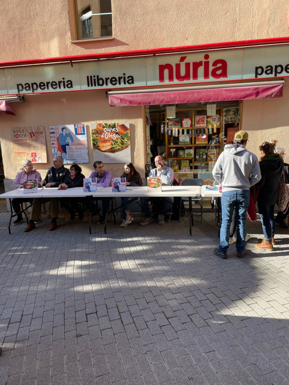 Signatura de llibres per autors locals a la porta de la llibreria Núria