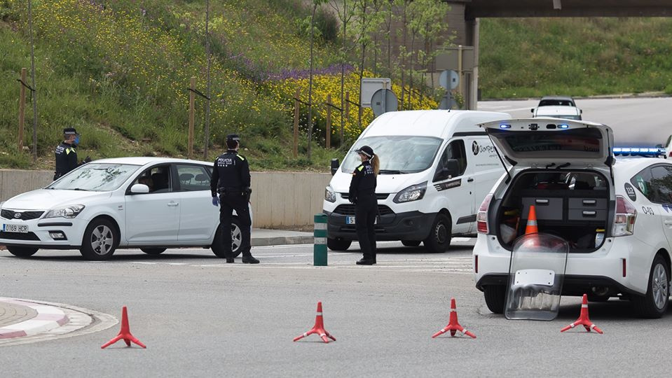 Control Policial a l'entrada d'Olesa. Dos policies i una dona policia paren dos vehicles