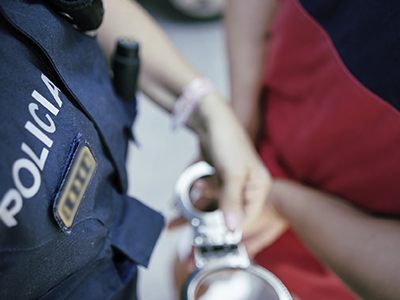 primer pla policia posant manilles a un detingut